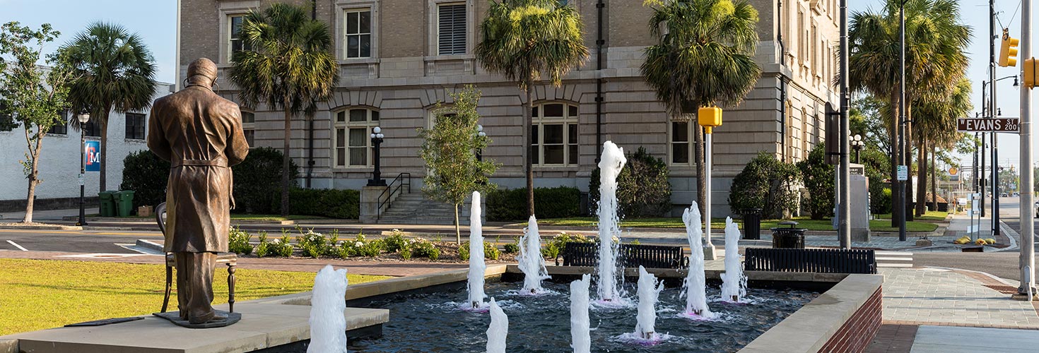 Statue and water fountains in downtown setting